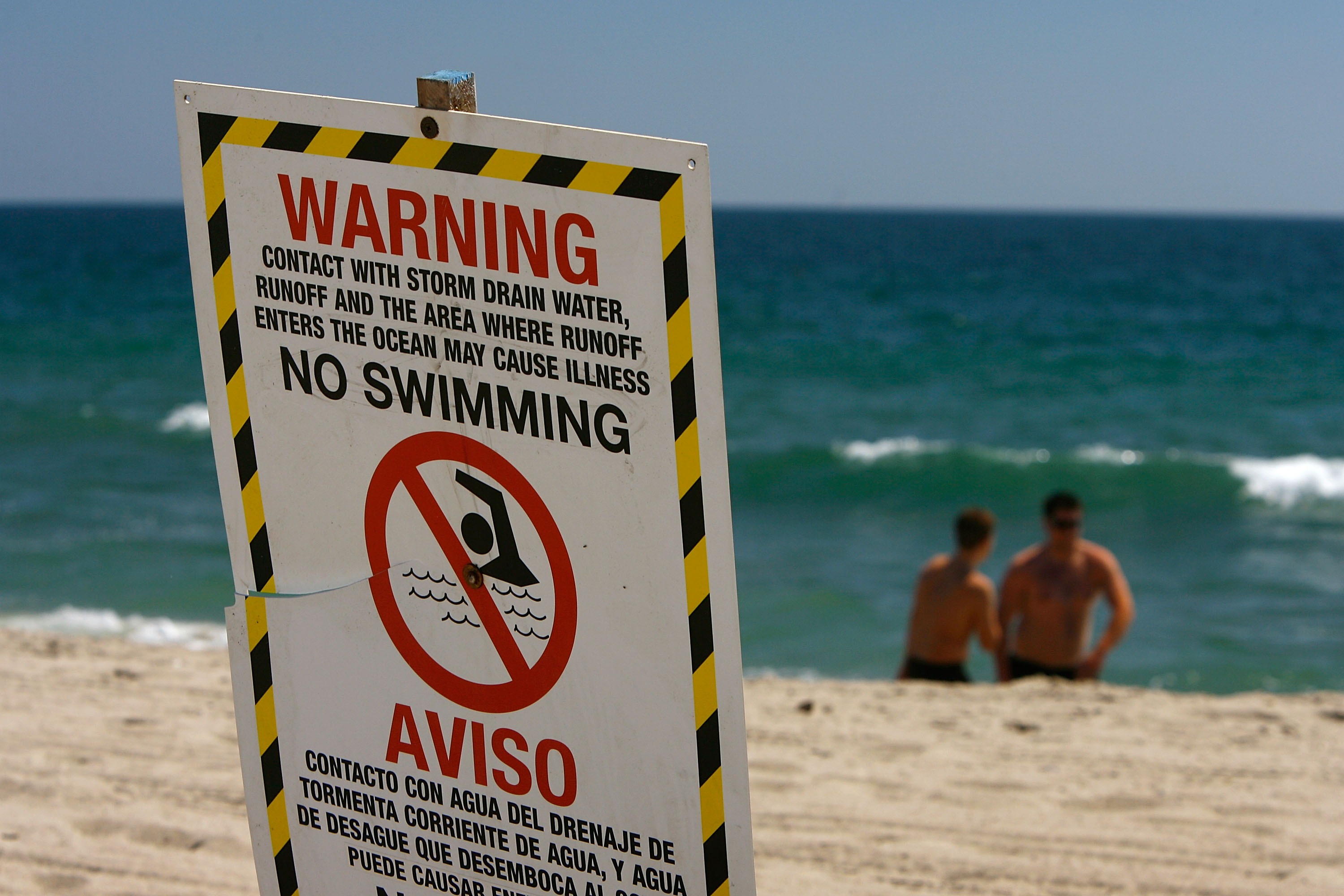 Signs warn the public to stay out of the water in an area harboring high bacteria levels near a drain at Will Rogers State Beach on Aug. 7, 2007, in Pacific Palisades. (Credit: David McNew/Getty Images)
